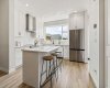 The heart of the home is a bright, thoughtfully designed kitchen featuring crisp white cabinetry, quartz countertops, stainless steel appliances, and a large island that naturally brings everyone together.