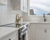 Thoughtfully appointed with timeless finishes, this chef-inspired space features sleek quartz countertops, crisp white cabinetry, a modern tile backsplash, and an abundance of prep space for every occasion.