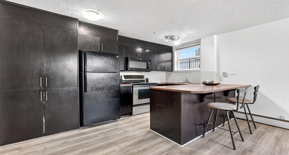 Kitchen is fully equipped with a fridge, stove, dishwasher, and microwave, plus pantry-style cabinets