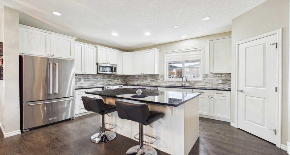This beautifully appointed kitchen features a large island, updated stainless steel appliances, and an ideal blend of style, comfort, and functionality.