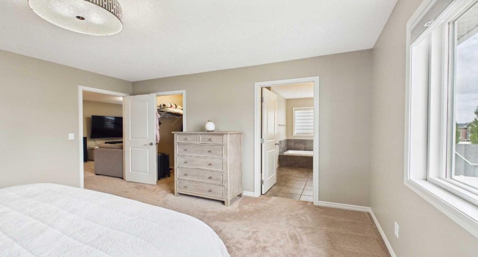 Another angle of the spacious primary bedroom showcases direct access to the walk-in closet and the well-appointed 5-piece ensuite.