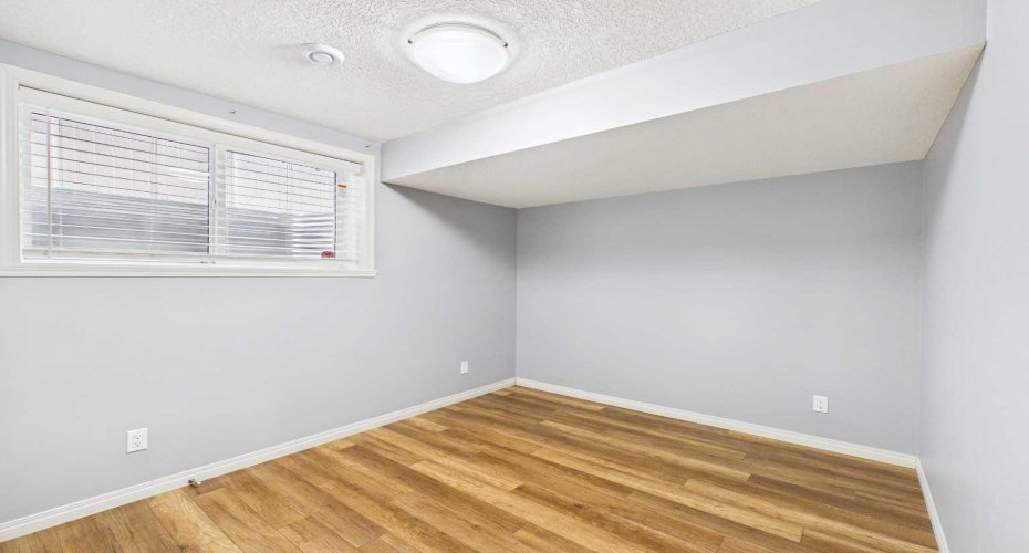 Illegal Basement Suite: Bedroom 2 is spacious and features a good-sized closet and a large egress window that provides ample natural light and an emergency exit for safety. This bedroom is part of an illegal (non-conforming) basement suite that has not been approved as a legal secondary suite.