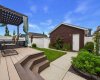 Backyard: Beautifully landscaped and meticulously maintained backyard featuring a low-maintenance fence and durable composite decking, designed to withstand harsh weather conditions while providing an attractive and functional outdoor living space