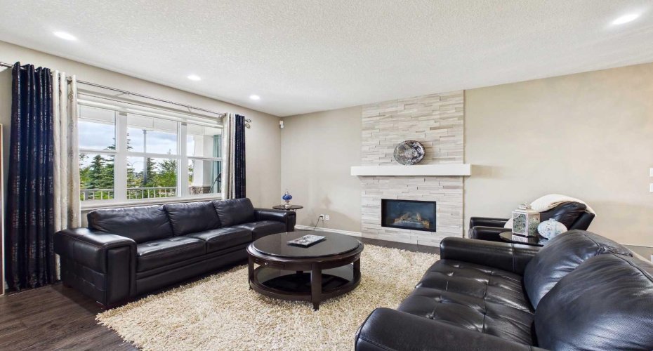 Warm and inviting main-floor living area with a cozy fireplace, flowing effortlessly through a thoughtfully designed open-concept floor Plan