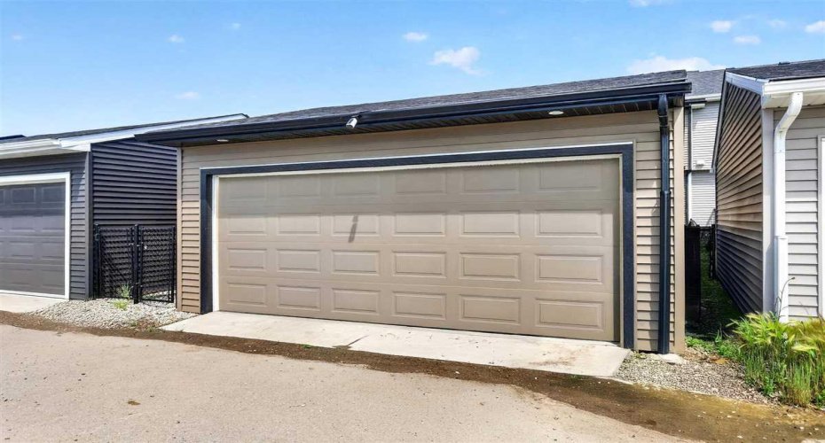 Paved back lane leads to double garage