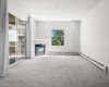 Bright sunny living room with gas fireplace and access to the balcony
