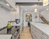 A view of the kitchen from the window. Look at the large island, those stunning Rosa Aurora Marble countertops, and the brass accents.