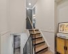 This is the stairway landing on the 4th level with the stairs leading to the primary bedroom on the 5th level. The kitchen is on the level below.