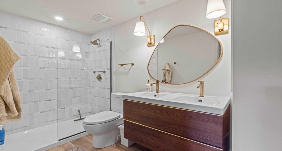 4-piece ensuite bathroom for the Primary Bedroom. Note the walk-in shower and double sinks, along with stunning brass accents.