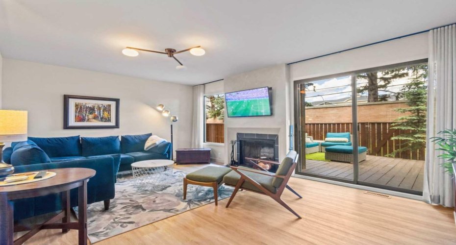 The living room. This is a bright space with sliding glass doors leading to the private outdoor living space. Note the wood-burning fireplace.