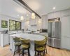 This is a gorgeous kitchen. Note the Rosa Aurora Marble countertops, the breakfast bar, the stainless steel appliances and the brushed brass accents.