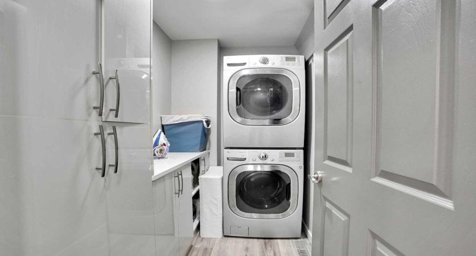 Upper Laundry room with stacked washer and dryer
