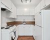 All white cabinets and well maintained appliances with an LVP floor