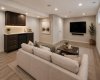 The FINISHED BASEMENT expands your living space with a spacious recreation area and WET BAR—ideal for movie nights, game days, or entertaining guests. This photo has been virtually staged to show possibilities of the space (Couch , coffee table , additional feature lighting, plants and pictures).
