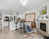 The inviting living room centres on a tiled gas fireplace, with bar seating and warm natural light creating a relaxed, social feel.