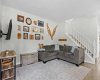 The family room connects to the upper level via a bright staircase with classic white spindle railings.