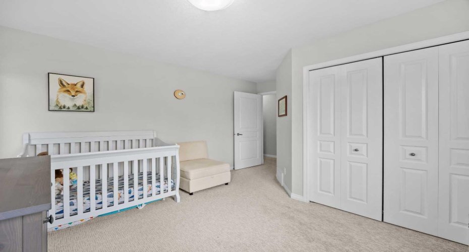 A generous second bedroom with double closet and large windows, easily suited as a child's room or guest space.