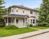 Charming two-storey with a classic wrap around porch and timber accented entry, set on a manicured corner lot framed by mature spruce.