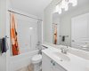 The upstairs four piece main bath is bright and well kept, with a full tub and shower combination.