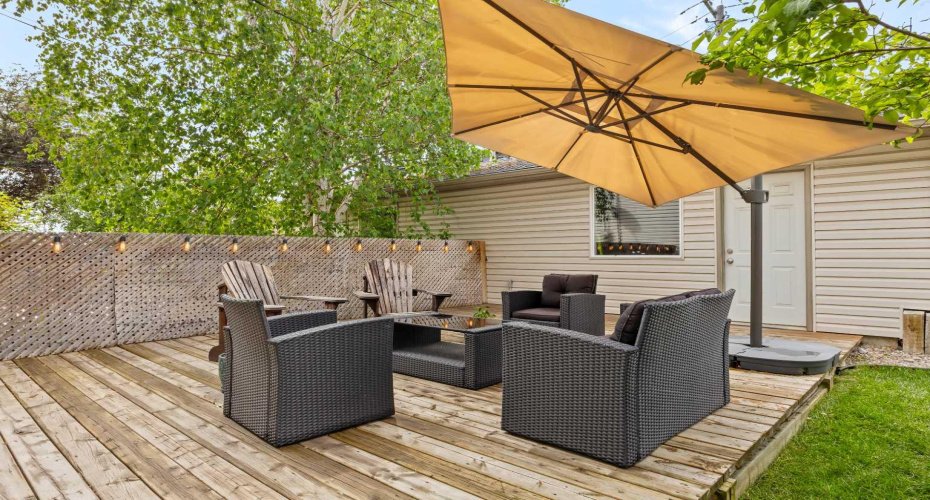 A private backyard deck framed by lattice screening and string lights, made for evening gatherings and quiet mornings alike.
