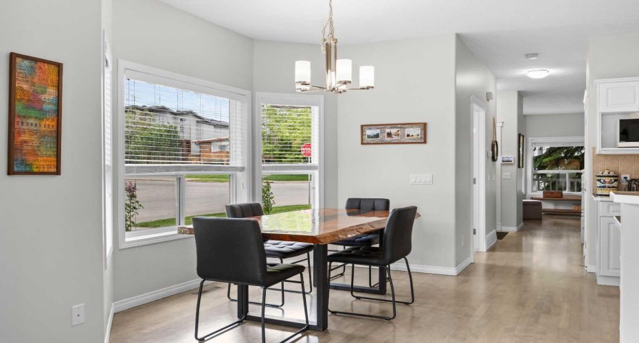 Wide plank flooring and crisp white trim carry the eye down the hall, connecting the dining space to the front of the home.