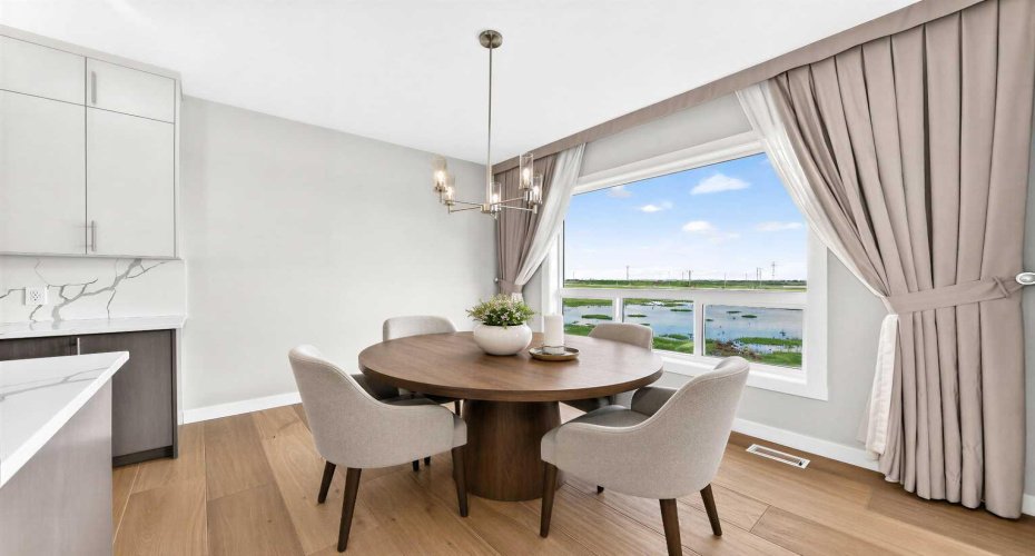 Fantastic dining area overlooking the storm pond.   Virtually staged