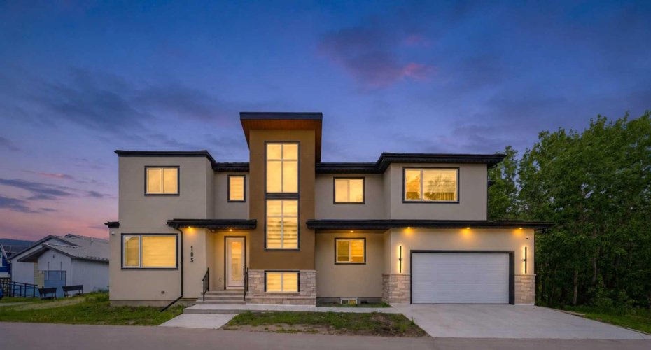 Striking evening presentation showcases the home's modern architecture, premium finishes, and exceptional curb appeal.