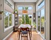 The dining area sits beneath soaring ceilings and walls of windows that make every season feel like something worth watching — pancake breakfasts never had a better backdrop.