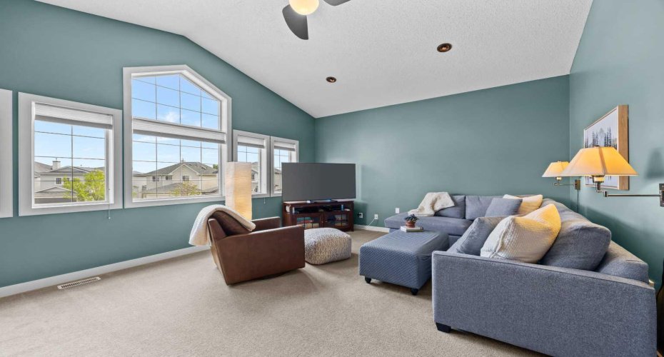 That dramatic arched window and soaring vaulted ceiling give this room a sense of openness you don't often find on a second floor.
