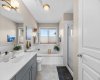 The 4-piece ensuite delivers the best of both worlds — a deep soaker tub beneath the window and a separate stand-up shower for the mornings that move fast.