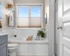 Candle lit, book open, door closed — this tub is where long weeks come to an end.