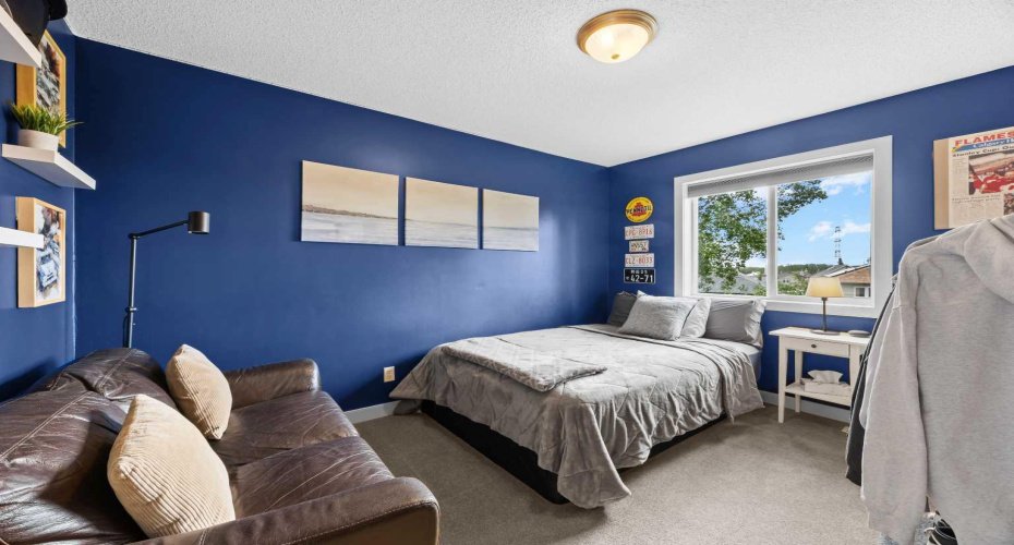 Bedroom three offers the same comfortable footprint — big window, great light, and enough space for a bed and a hangout zone.