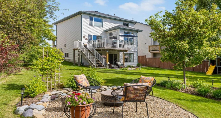 Here's an early peek at where this home truly shines — a massive pie-shaped backyard with a dedicated firepit area, mature landscaping, and a sweeping lawn built for slip-and-slides, yard games, and long summer evenings.