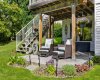 The walkout opens onto a covered stamped stone patio — shaded seating, garden views, and a quiet spot that works rain or shine.