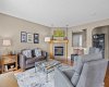 The living room brings genuine warmth, with updated hardwood floors, soaring ceilings, and a corner gas fireplace anchoring the space.