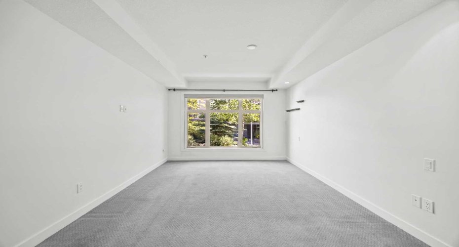A window wall overlooking the landscaped grounds, with motorized blackout blinds ready when you want the room dark and quiet.