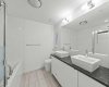 Granite counters and vessel sinks carry the kitchen's finish level straight through to the ensuite.