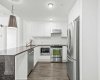 Upgraded waterfall granite countertops anchor a kitchen that was done right from the start, with seating at the bar and workspace that flows.