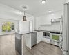 The kitchen sets the tone — waterfall granite, full-height cabinetry, and pendant lighting opening naturally onto the living and dining space.