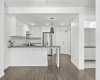 A kitchen designed to be lived in — prep space, storage, and seating all in one sightline, opening directly onto the heart of the unit.