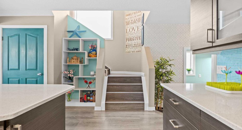A bright staircase leads to the upper level, framed by a custom built-in display nook and a playful pop of colour. Little moments of personality that make this house feel like a home.