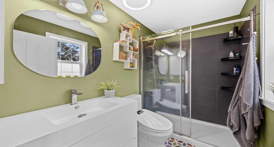 A crisp, modern bathroom with a floating vanity, walk-in glass shower, and a cheerful pop of colour. Clean lines and thoughtful finishes make everyday routines feel like a getaway.