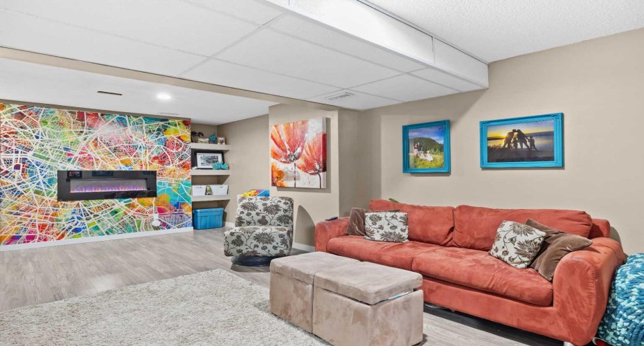 A striking fireplace feature wall anchors this welcoming lounge — the perfect retreat for relaxing, hosting, or letting the kids play. Full of warmth and character.