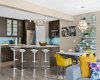 Kitchen, dining, and living move together as one bright, connected space. Pops of colour — the living plant wall, the sunny dining chairs — bring personality and life to the main floor.