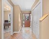 The foyer welcomes you home with tile flooring, a coat closet, and a view straight through to the office and staircase.