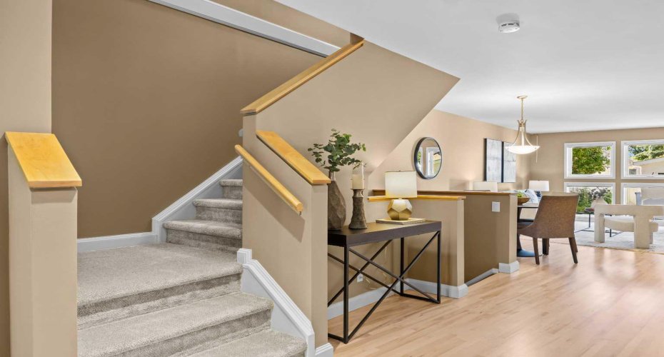 The staircase connects the main living space to the upper level, with warm tones carried throughout.