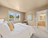 The primary bedroom offers a peaceful retreat with tree-lined views and direct access to its own ensuite.