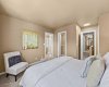 This bedroom's layout includes a walk-in closet and ensuite access, along with a view down the hallway.