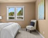 The primary bedroom offers a peaceful, light-filled retreat with a tree-lined window view.