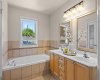 A deep jetted soaker tub tucked beneath a window makes for a relaxing soak after a long day.